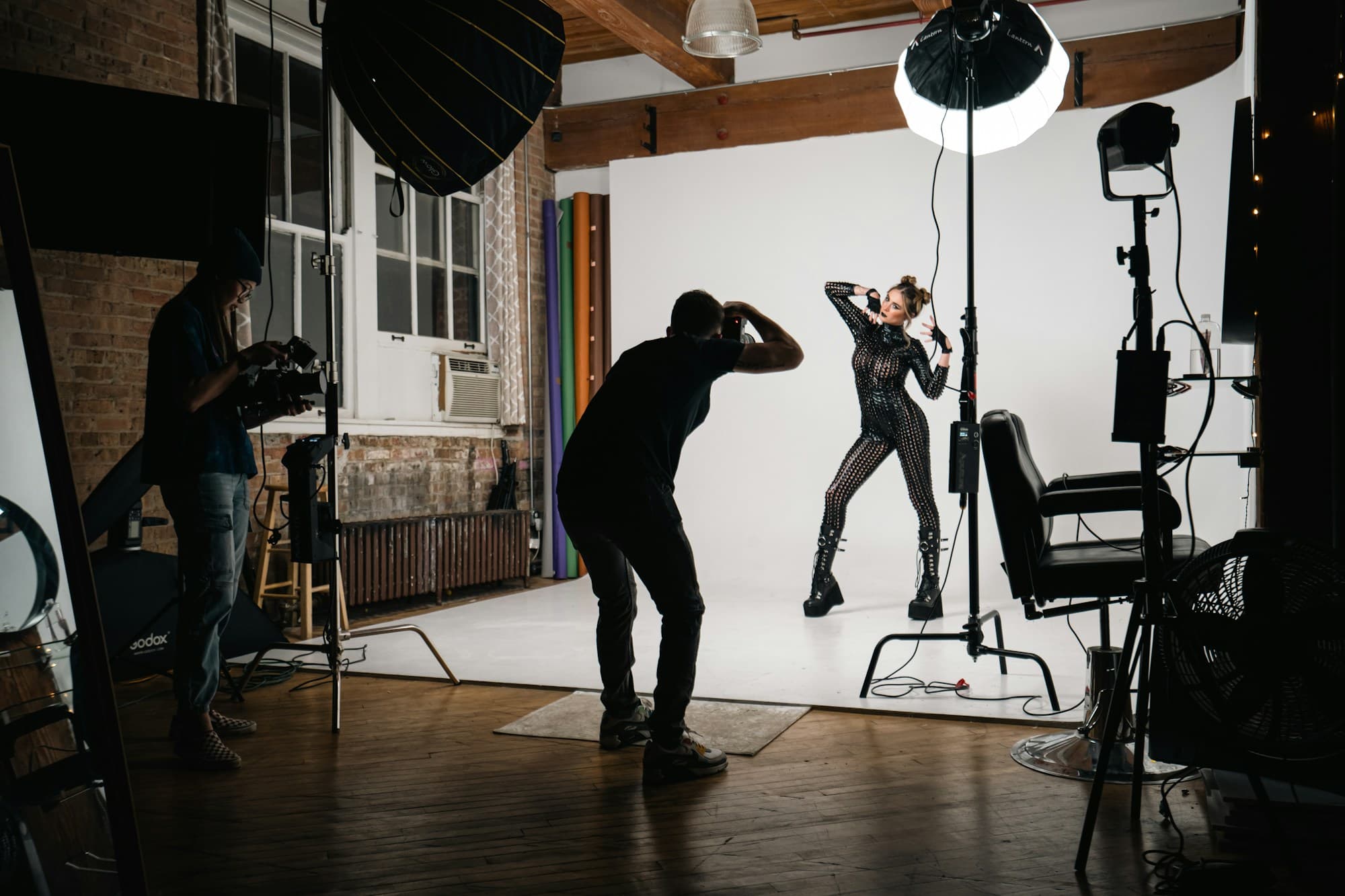 A photographer shooting a model against a studio backdrop